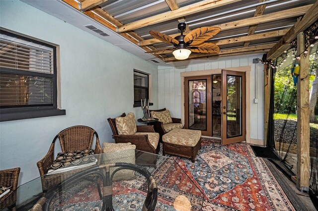 interior space with beam ceiling, visible vents, and a ceiling fan