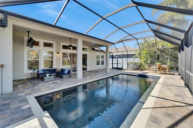 view of swimming pool featuring ceiling fan, a patio, outdoor lounge area, and glass enclosure