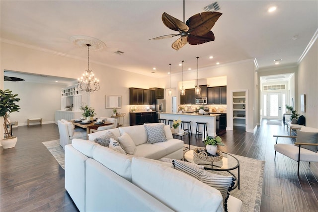 living room with ornamental molding, ceiling fan with notable chandelier, and dark hardwood / wood-style flooring