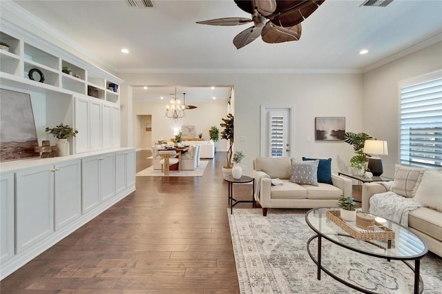 living room with crown molding, dark hardwood / wood-style flooring, and ceiling fan with notable chandelier