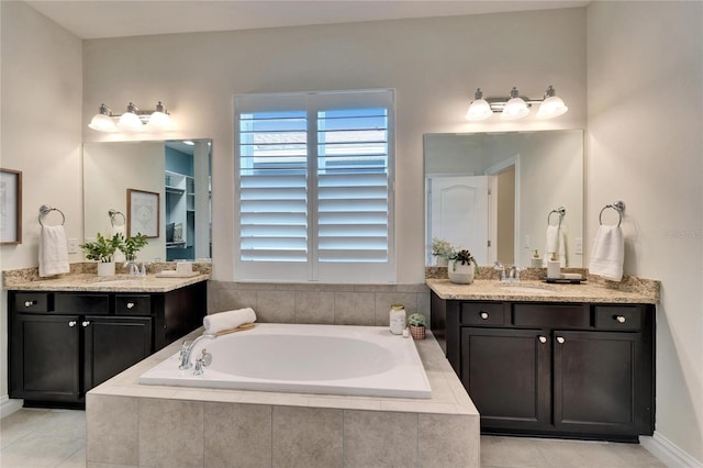 bathroom featuring tile patterned flooring, tiled tub, and vanity