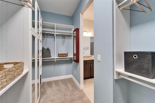 walk in closet with light colored carpet