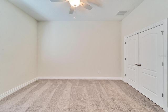 spare room featuring light carpet and ceiling fan