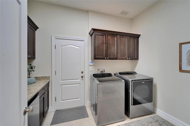 laundry area with cabinets, washer and dryer, and light tile patterned floors