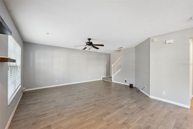 spare room with ceiling fan, hardwood / wood-style floors, and a textured ceiling