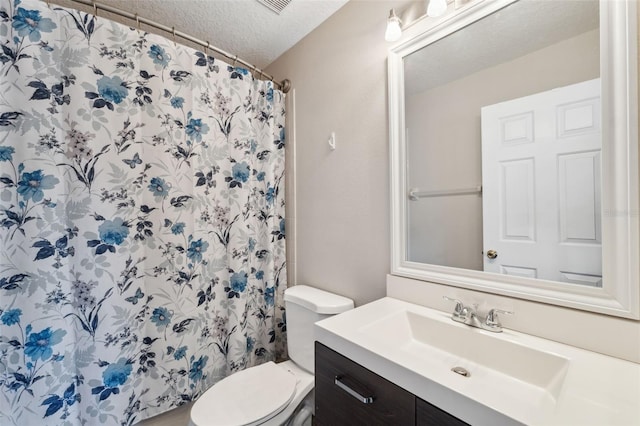 bathroom featuring vanity, curtained shower, a textured ceiling, and toilet