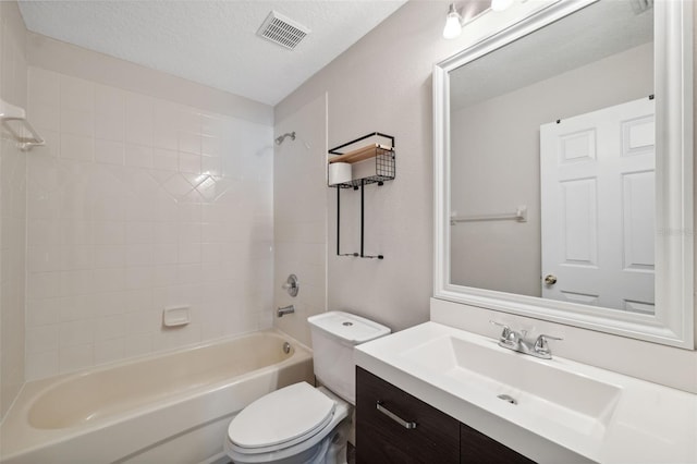 full bathroom with vanity, a textured ceiling, toilet, and tiled shower / bath