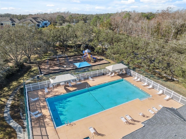 view of swimming pool with a playground and a patio