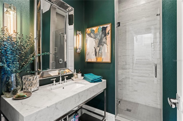 bathroom with a shower stall and vanity