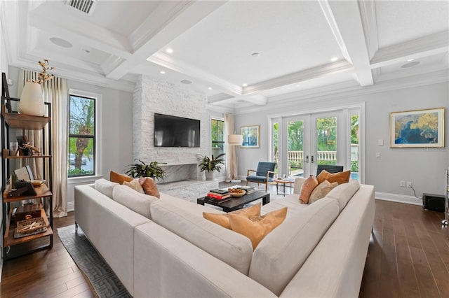 living area with a wealth of natural light, dark wood-style flooring, french doors, and a stone fireplace