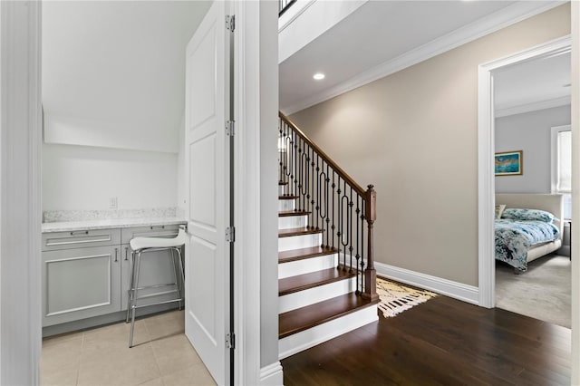 stairway featuring ornamental molding, recessed lighting, wood finished floors, and baseboards