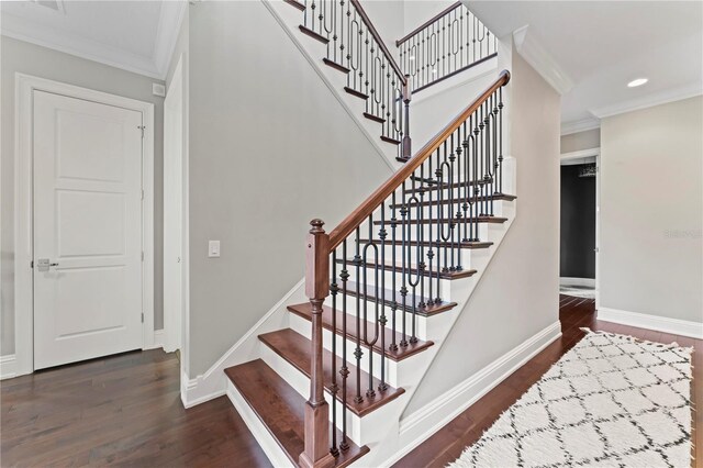 stairway featuring baseboards, wood finished floors, and crown molding