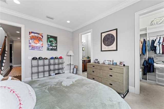 bedroom with carpet floors, ornamental molding, a walk in closet, and baseboards