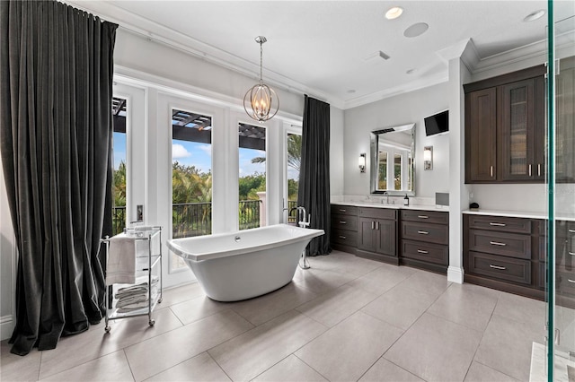 full bath with tile patterned floors, crown molding, a freestanding bath, and vanity