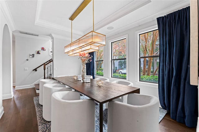 dining space featuring ornamental molding, dark wood-style flooring, a raised ceiling, and stairs