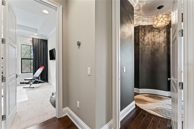 bathroom featuring a raised ceiling, wood finished floors, and baseboards