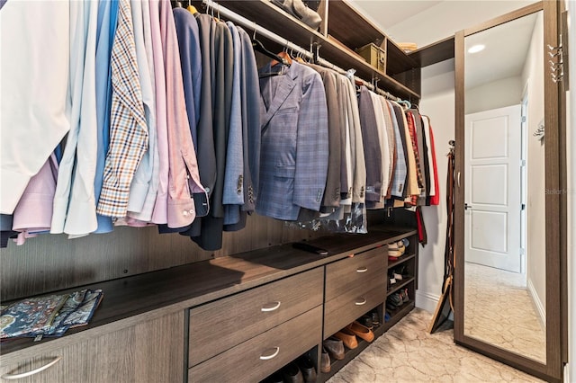 walk in closet featuring marble finish floor