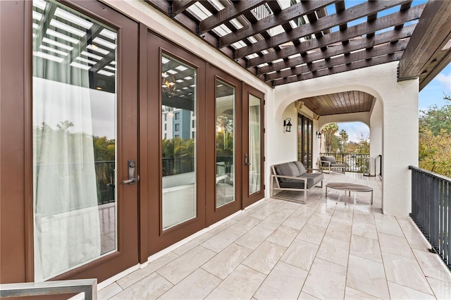 view of patio featuring a balcony, a pergola, and french doors