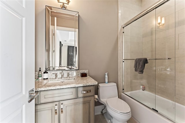 bathroom featuring enclosed tub / shower combo, vanity, and toilet