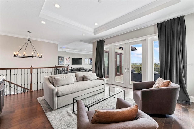 living room with a chandelier, wood finished floors, french doors, a raised ceiling, and crown molding