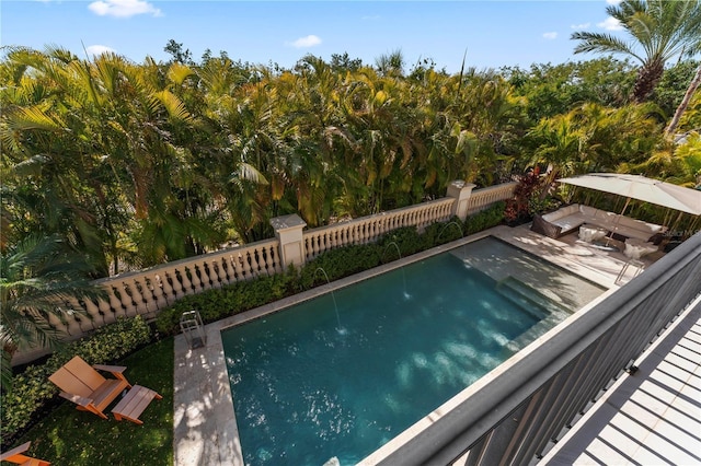 view of pool featuring a jacuzzi and fence