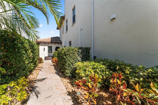 view of property exterior with a tile roof and stucco siding