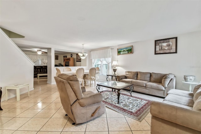 tiled living room featuring ceiling fan with notable chandelier