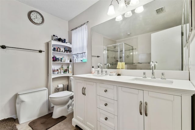 bathroom featuring tile patterned flooring, vanity, a shower with shower door, and toilet