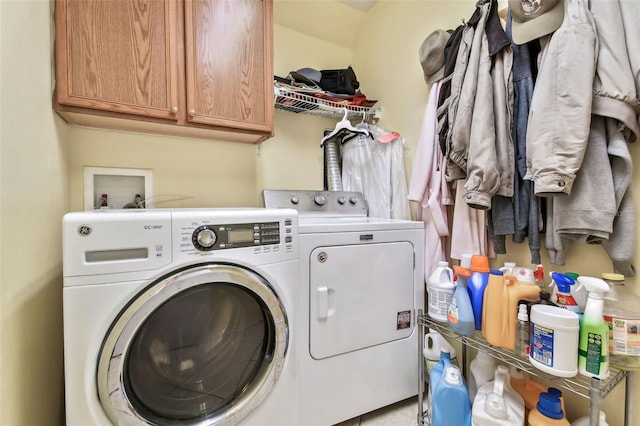 clothes washing area with cabinets and independent washer and dryer