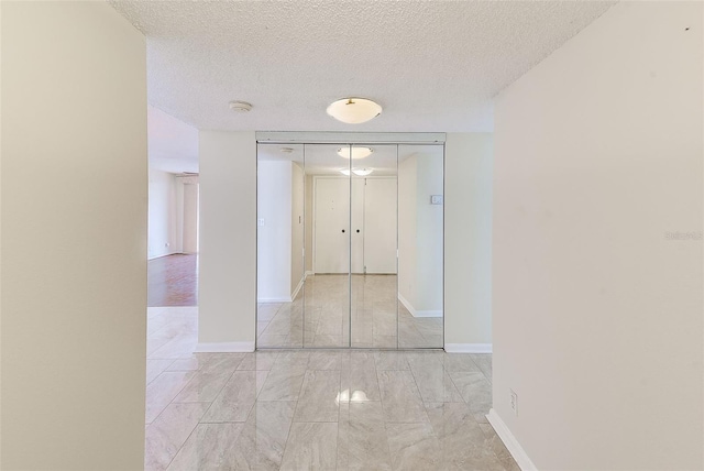 corridor featuring a textured ceiling