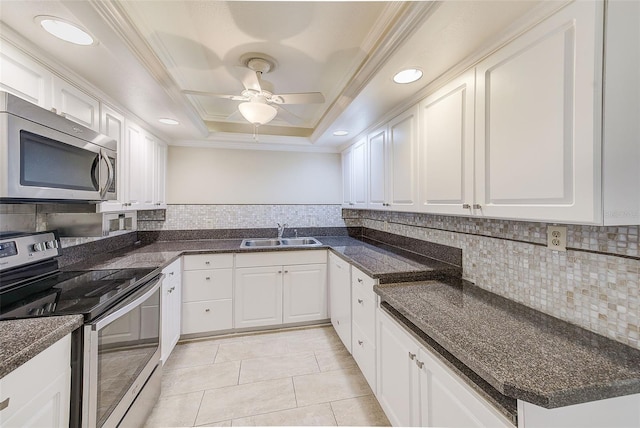 kitchen with sink, crown molding, stainless steel appliances, a tray ceiling, and white cabinets