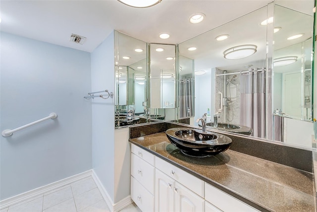 bathroom with an enclosed shower, vanity, and tile patterned floors