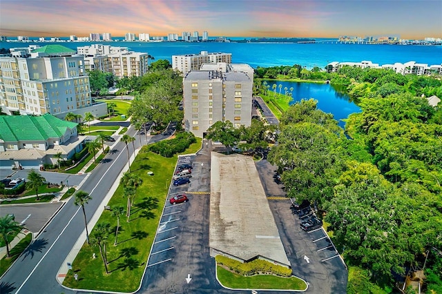 aerial view at dusk featuring a water view