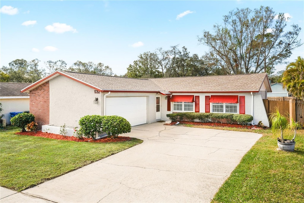 ranch-style home with a garage and a front yard