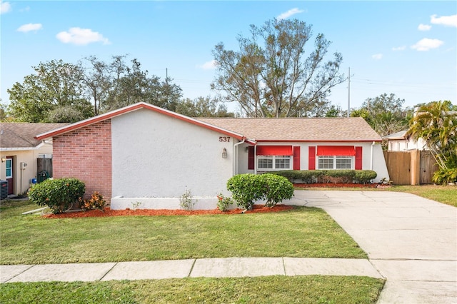 ranch-style house featuring central air condition unit and a front lawn