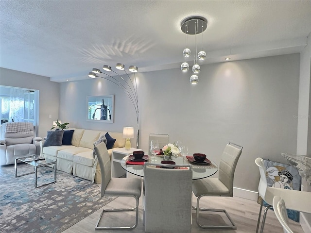 dining space with a textured ceiling and light wood-type flooring