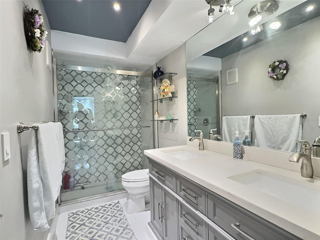 bathroom featuring vanity, a shower with shower door, and toilet