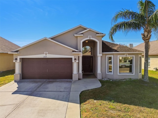 single story home featuring a garage and a front lawn