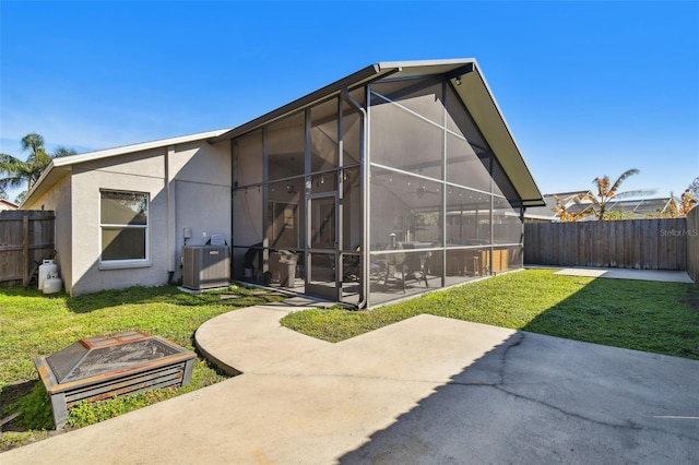 rear view of house with a lawn, a lanai, central AC, and a patio area