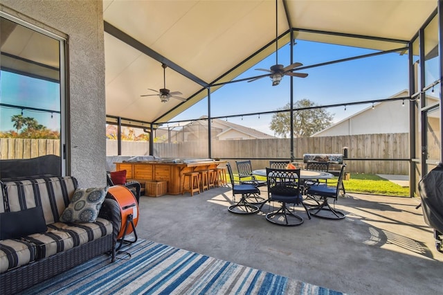 view of patio featuring ceiling fan and exterior bar