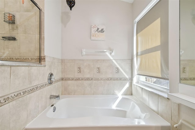 bathroom with a tub and tile walls