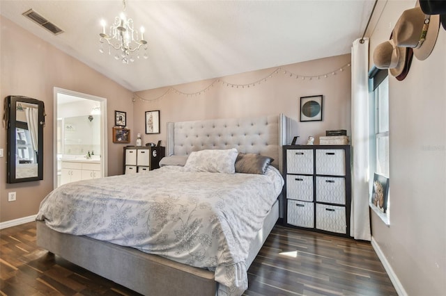 bedroom featuring dark wood-type flooring, ensuite bath, lofted ceiling, and an inviting chandelier