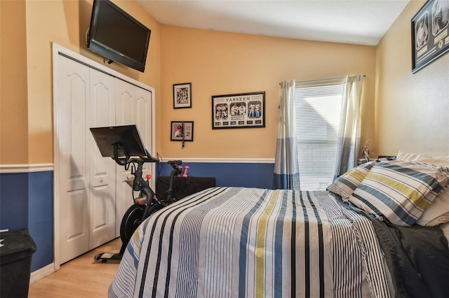 bedroom featuring lofted ceiling and light wood-type flooring