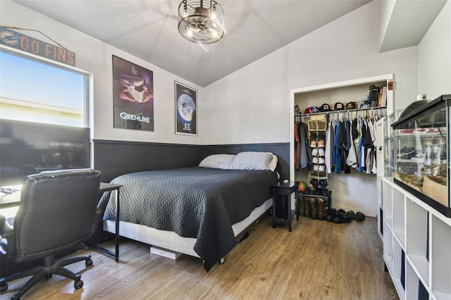 bedroom with lofted ceiling, hardwood / wood-style floors, and a closet