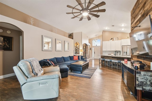 living room featuring sink, hardwood / wood-style flooring, high vaulted ceiling, and ceiling fan