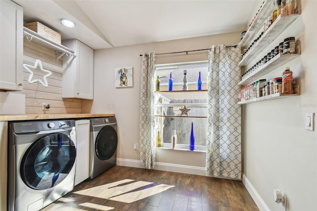 clothes washing area featuring separate washer and dryer, dark hardwood / wood-style floors, and cabinets