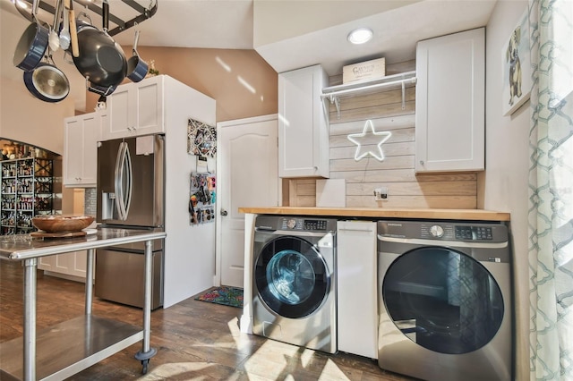 laundry area with cabinets, washing machine and clothes dryer, and dark hardwood / wood-style flooring