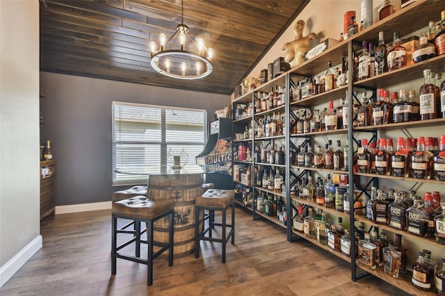 interior space with dark wood-type flooring, bar, a notable chandelier, vaulted ceiling, and wooden ceiling