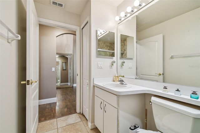 bathroom featuring tile patterned flooring, vanity, and toilet