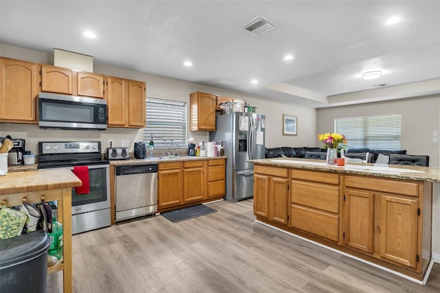 kitchen with visible vents, light wood-type flooring, a sink, appliances with stainless steel finishes, and light countertops